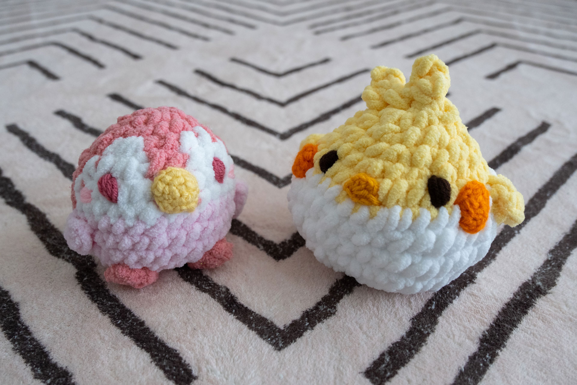 a chunky pink penguin and a yellow cockatiel