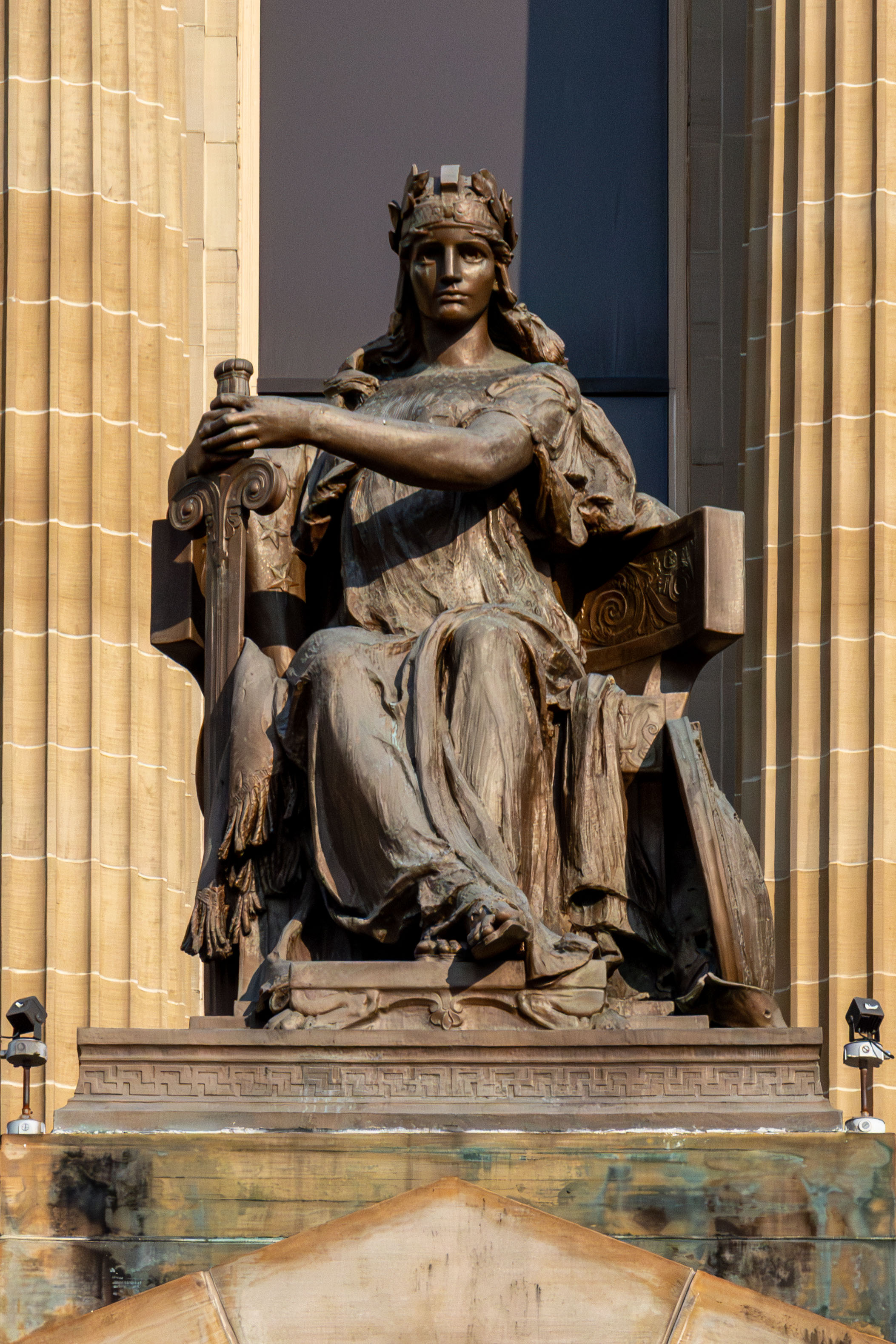 statue of goddess-looking woman holding a sword and a book